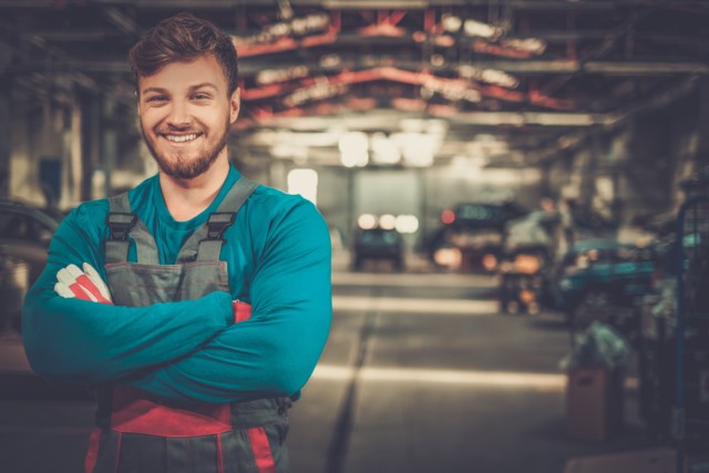 Cheerful serviceman in a car workshop